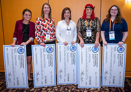 5 women holding large checks