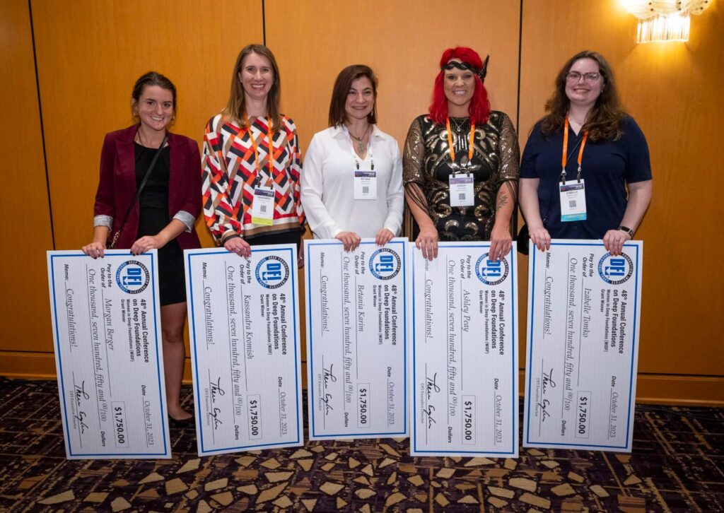 5 women posing with checks