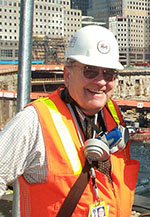 smiling elderly man wearing a hard hat and high-visibility vest