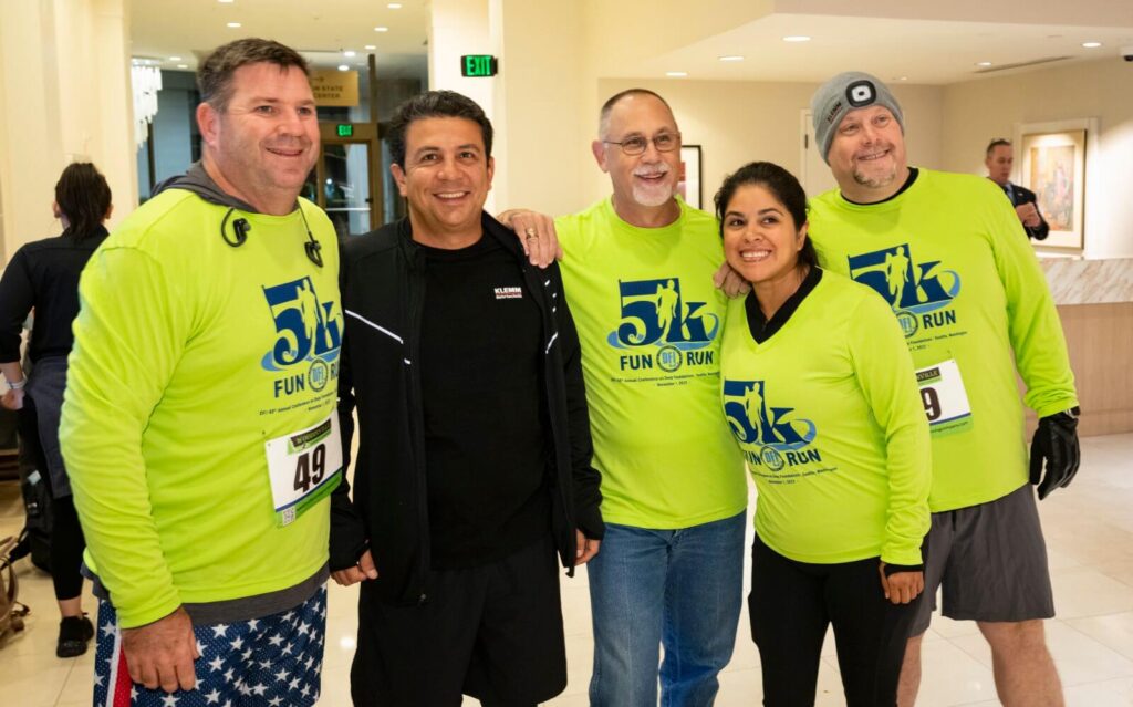 group of 5 adults in hi-vis clothing posing in lobby