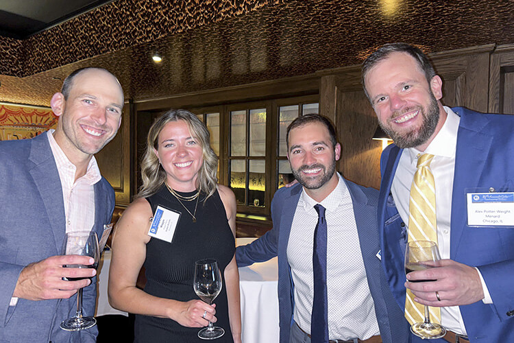 3 men and a women in formal wear posing with drinks